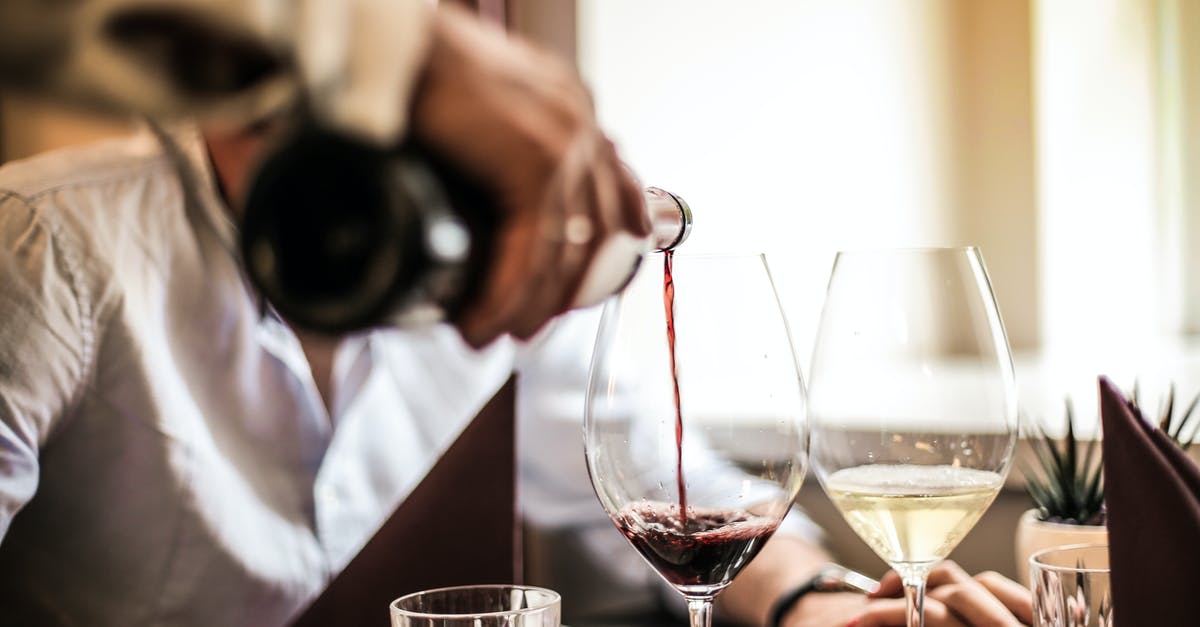 Substituting white wine vinegar with red wine vinegar - Crop man pouring red wine in glass in restaurant