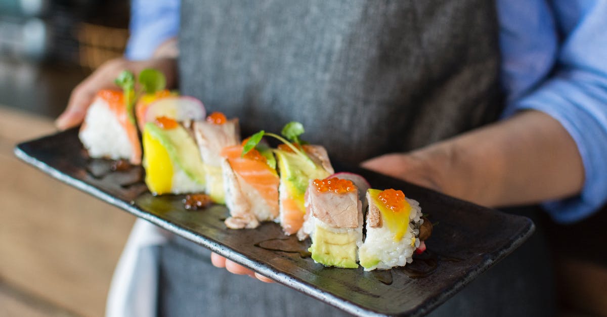 Sushi rolls keep getting thin - Person Holding Sushi on Black Plate