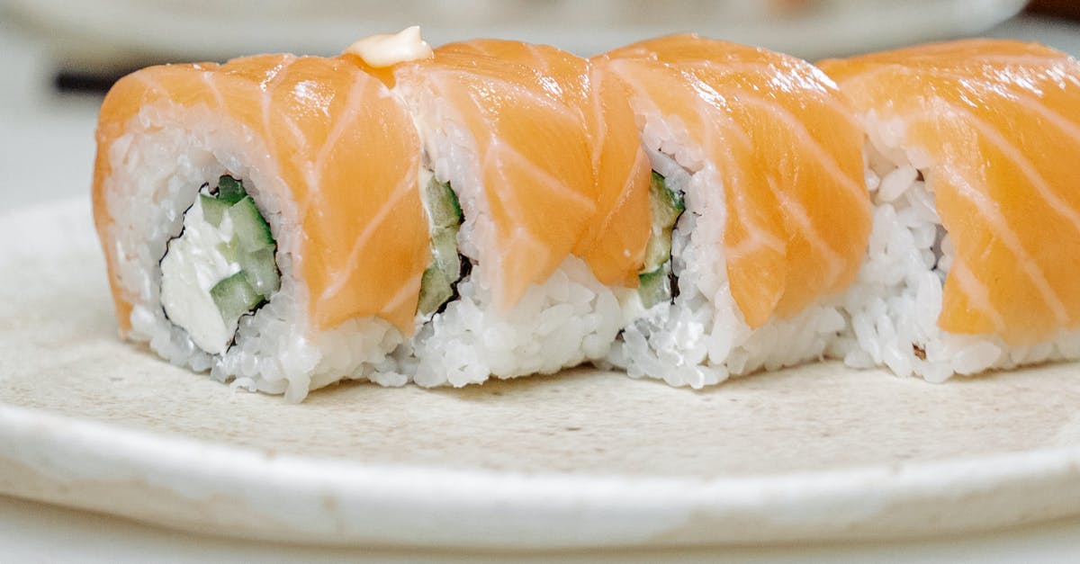 Sushi rolls opening up - Sliced Salmon on White Ceramic Plate
