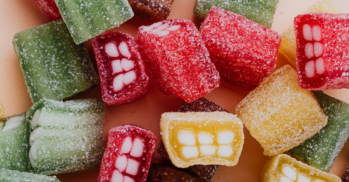 Sweet = Sugar, Salty = Salt, Sour =? - Set of colorful sour gummy sweets in sprinkle assorted chaotically on beige surface