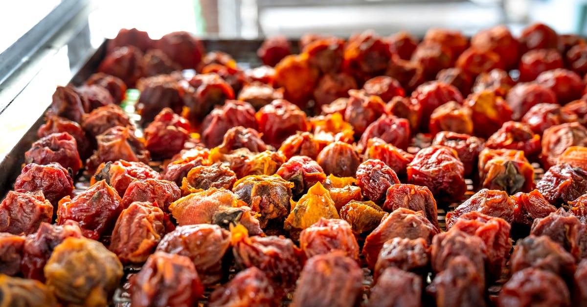 Sweet potatoes stored in direct sunlight - From above pile of Hoshigaki styled sun dried persimmons placed on metal tray in local market