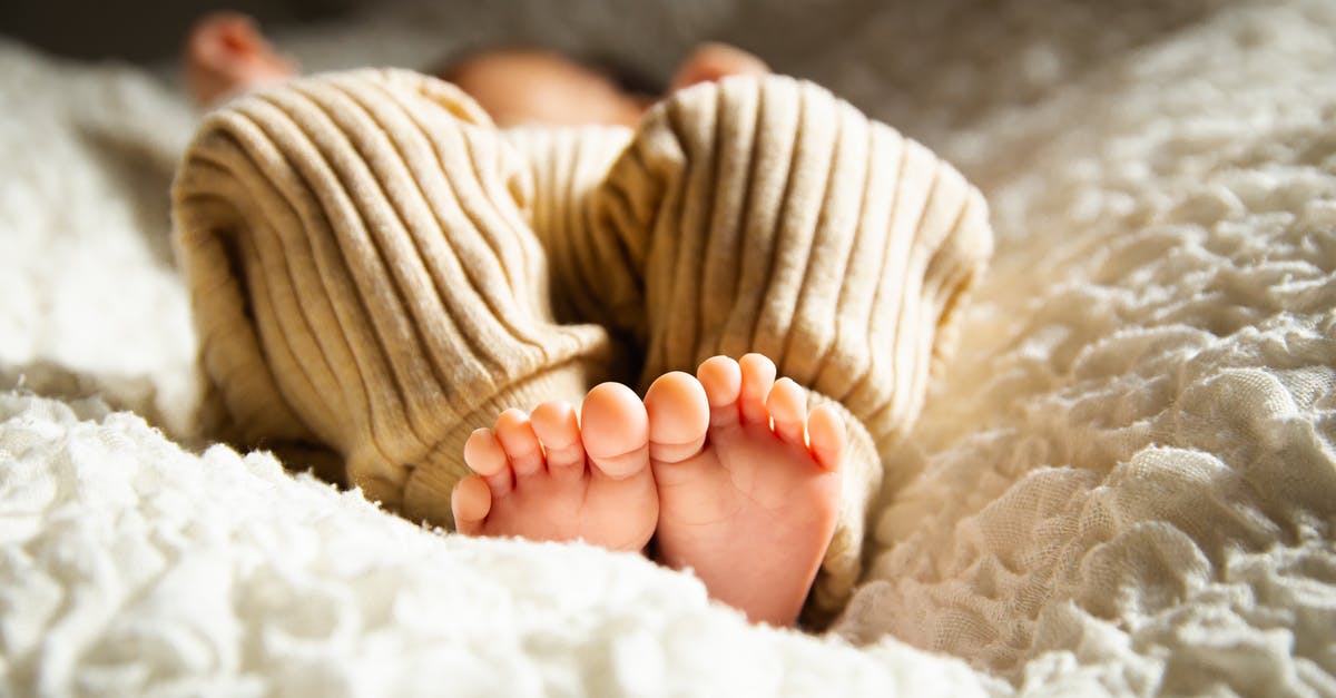 Sweet potatoes stored in direct sunlight - Anonymous barefooted baby sleeping on soft bed in sunlight