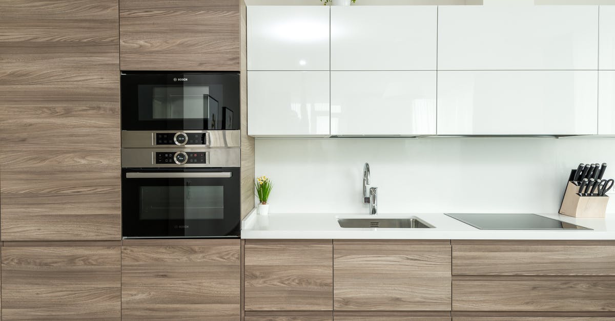 T function in OTG oven - Interior of modern kitchen with white and wooden minimalist cabinets and built in appliances in apartment