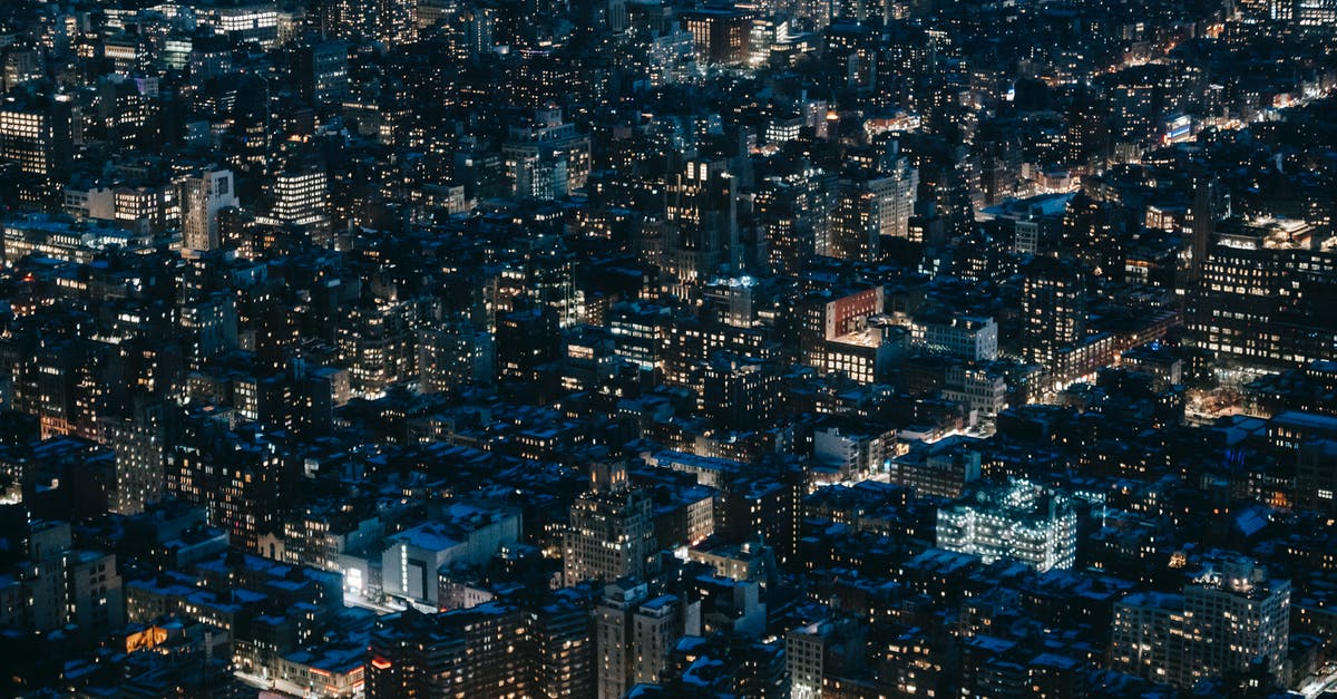 Tall cupcakes that have height to them - Aerial view of contemporary city with multistory residential buildings and roads and luminous lights at night