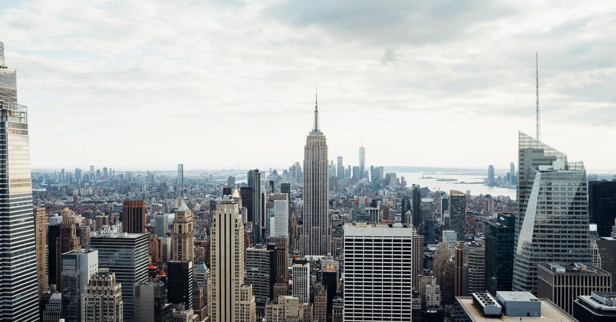 Tall cupcakes that have height to them - Drone view of empire state building located amidst high rise buildings on Manhattan in New York city against cloudy sky