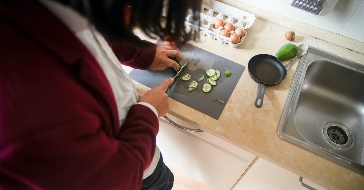 tamagoyaki eggs sticking to the pan - A Person Slicing Cucumber with a Knife