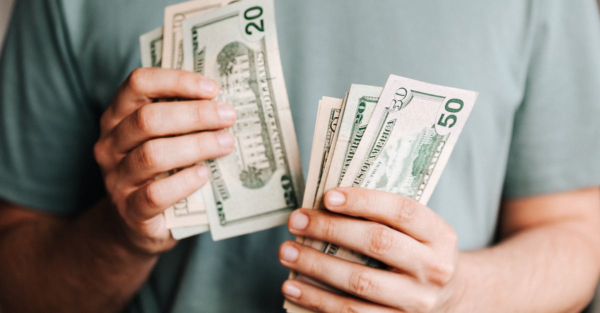 tarry deposit in wok - Crop man counting dollar banknotes