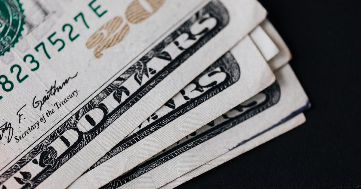 tarry deposit in wok - Pile of American paper money on black surface