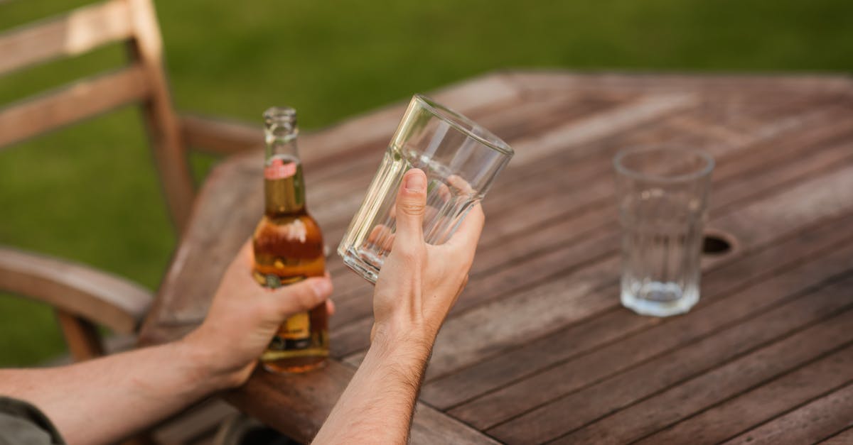 Taste difference of bottled beer vs. canned beer - Man with glass and beer bottle