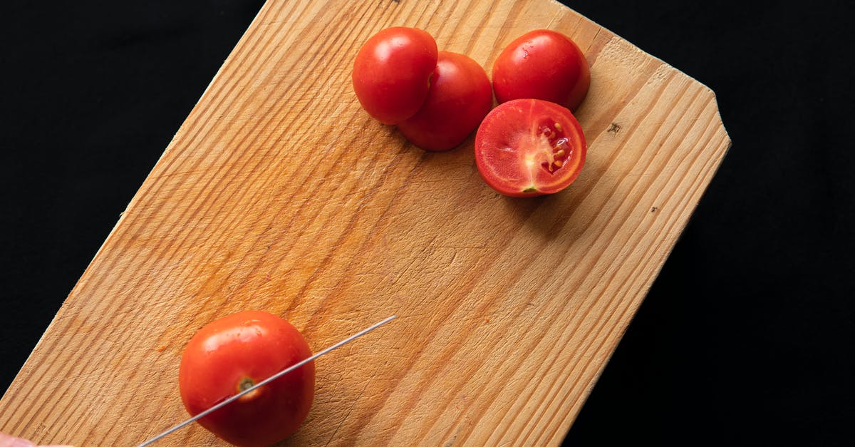 Taste-wise, is there a difference between tomato from a blender vs. chopped tomato? - Sliced ripe tomatoes on cutting board