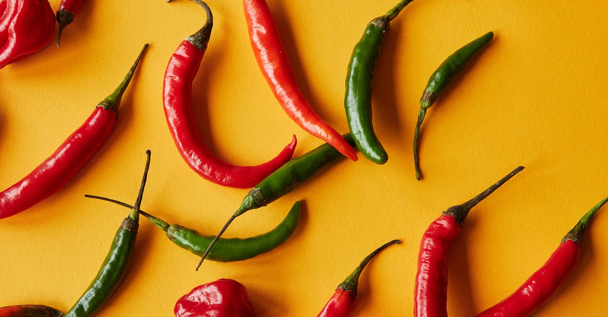 Tasting food in kitchen - Red and green peppers on yellow background