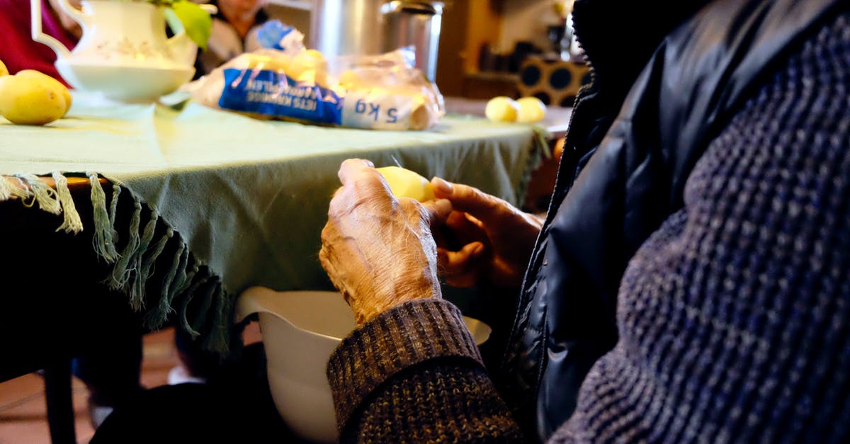 Technique for peeling boiled potatoes - Person in Black and Purple Jacket in Front of Gray Table Mat