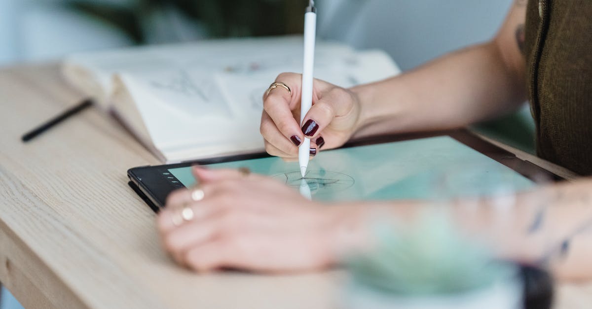 The art of Sushi: using wasabi to kill parasites - Crop unrecognizable female designer using tablet and stylus for drawing sketches on wooden table