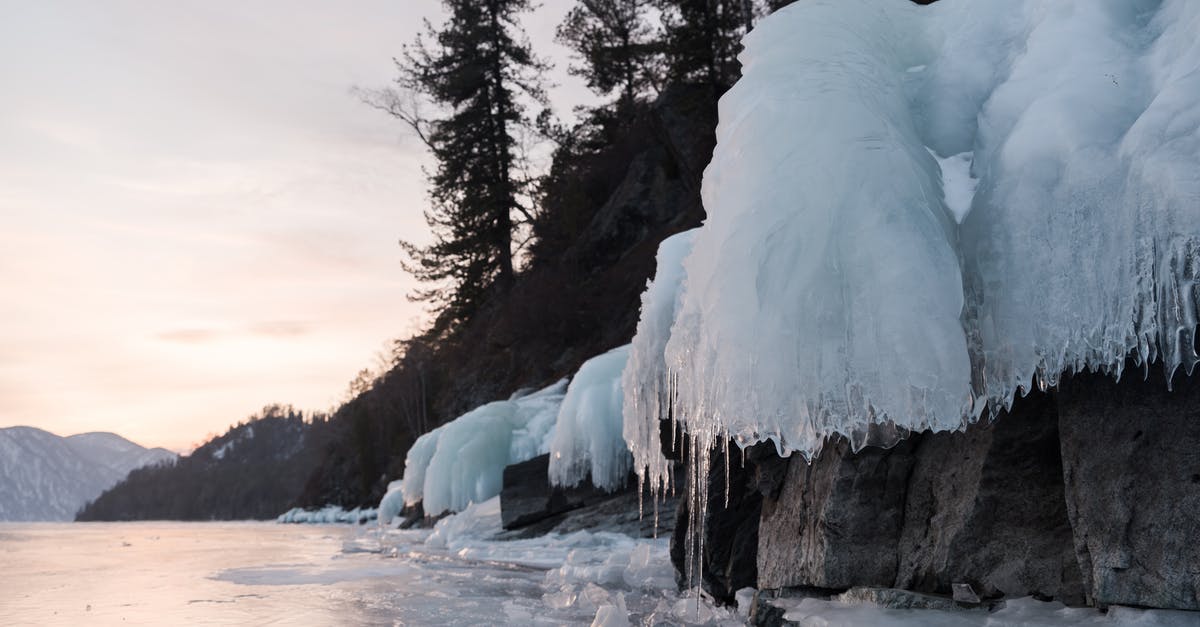 Thick carbon layer on wok? - Icicles on hillside near frozen lake under cloudy sky