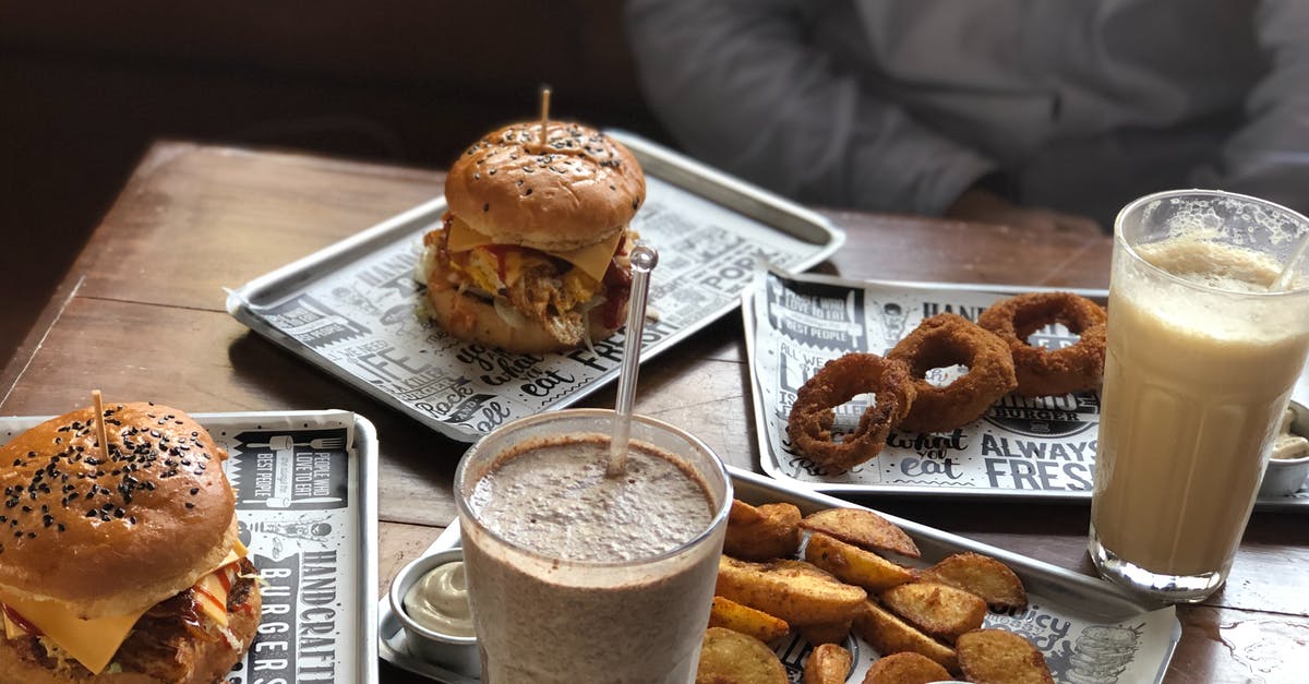 Thick Chocolate Sauce - Two Milk Shakes, Burgers, Fried Onion Rings and Wedge Potatoes on the Table