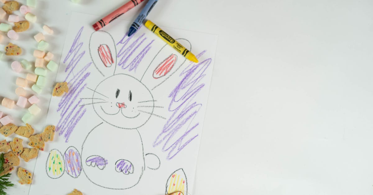 tiny quantity of egg in a cookie - Top view of colorful crayons and picture of bunny and eggs placed on white background with marshmallows and cookies during Easter holiday