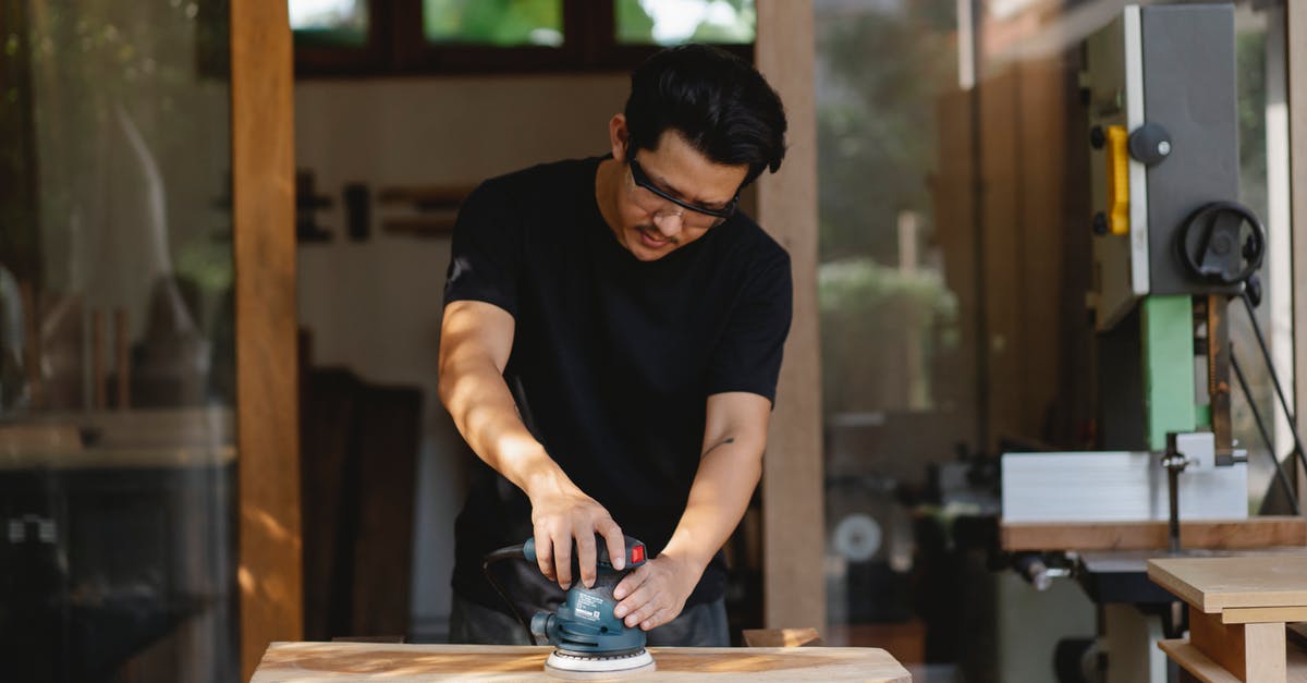 Tips for Creating a Creamy and Smooth Sorbet - Concentrated male master in protective glasses smoothing wooden plank with sander while creating wooden detail in workroom