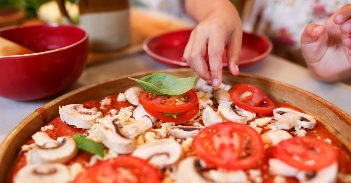 Tips To Make Pizza Dough Workable - Person Holding Sliced Tomato and Basil