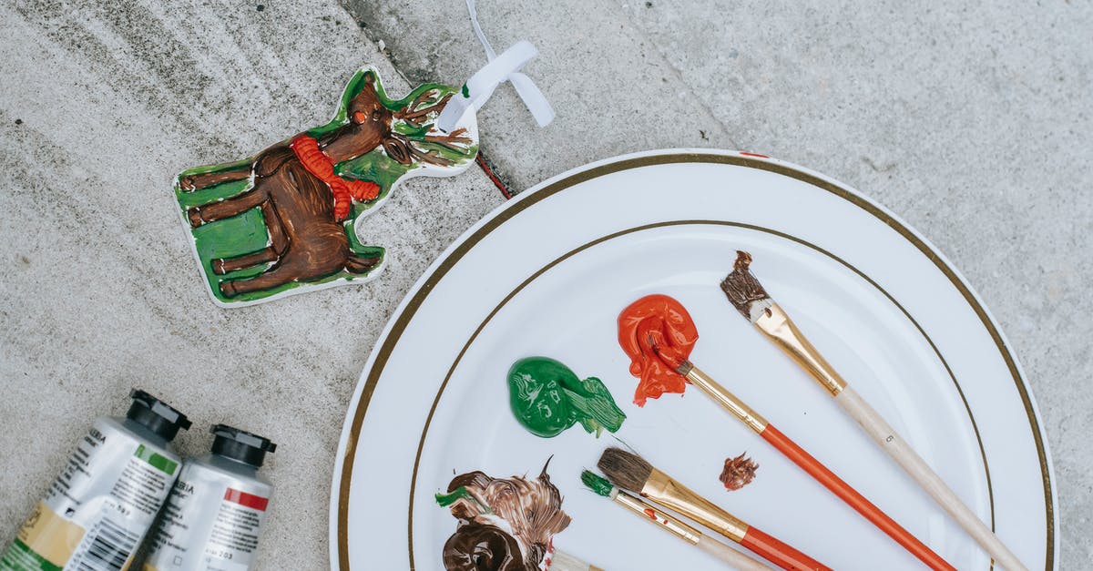 Tiramisu mixture not firm - Flat lay of Christmas deer near tubes placed near plate with brushes and mixture of colorful paints