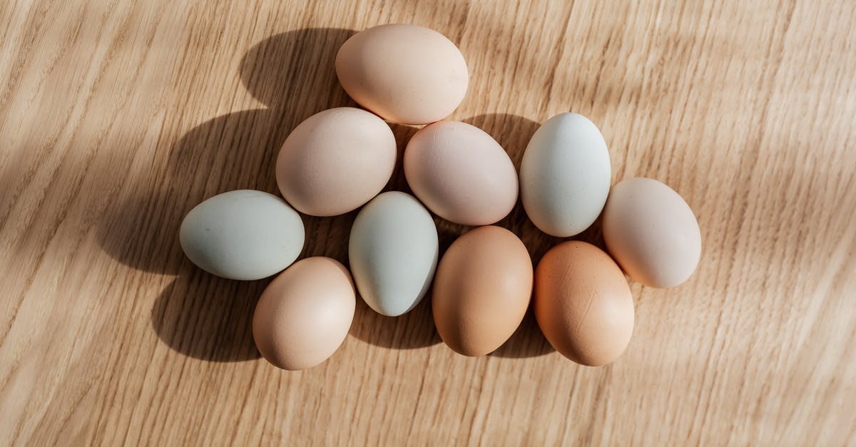 To boil frozen food with chicken without microwave - Top view set of organic pastel colored raw chicken eggs placed on wooden table in daylight