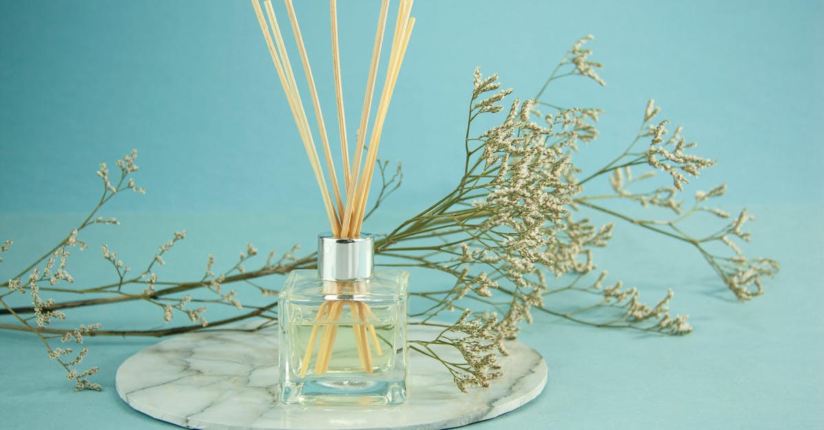 To finely spray a thin layer of warm liquid Coconut Oil? - Glass of natural essential oil with sticks