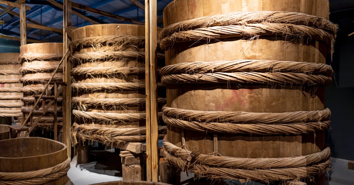To slow down the fermentation process of a food in a can - Wooden barrels on stands in local factory