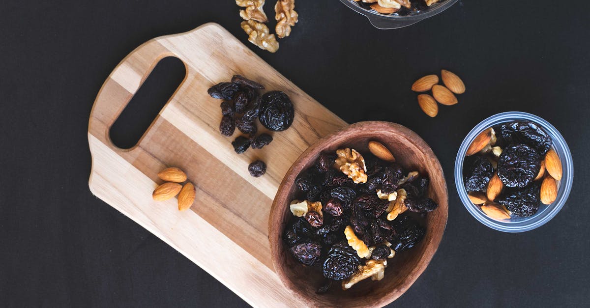 Toasting chopped almonds - Raisins and Nuts on Different Kinds of Bowl on the Black Surface