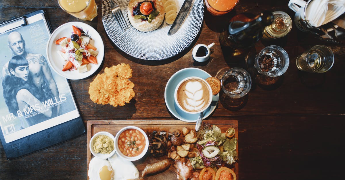 Tomato sauce - tomatoes, then juice vs tomatoes & juice - Top view of various dishes and tableware placed on wooden table and crop hands with folk and knife