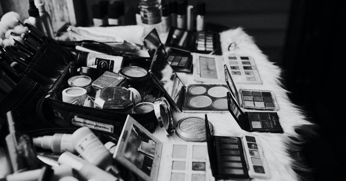 Toning down lamb with mustard powder: universal tool? - Black and white high angle of assorted makeup products and tools placed on dressing table near mirror