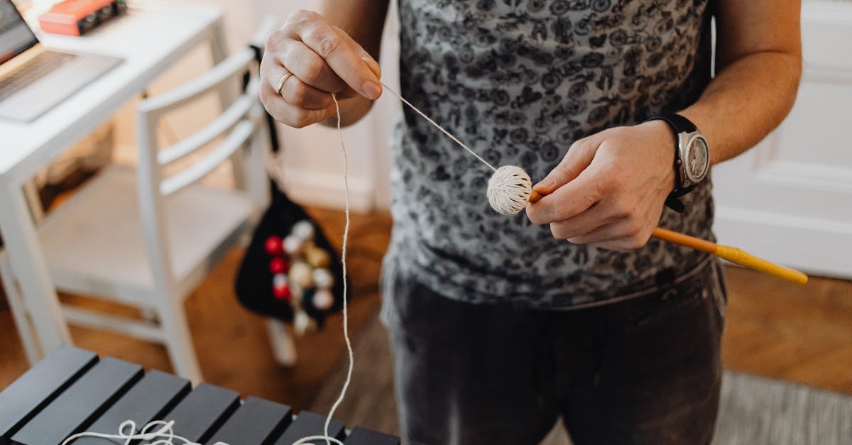 Tools for making Pasta - A Person Holding a Stick and Yarn