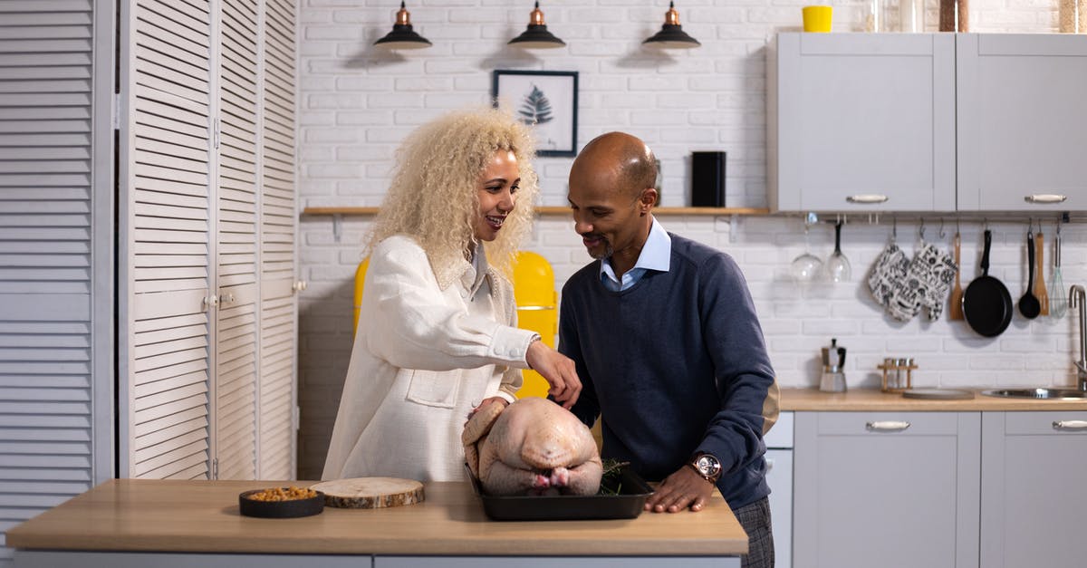 Turkey stock in refrigerator - Black couple preparing turkey for dinner