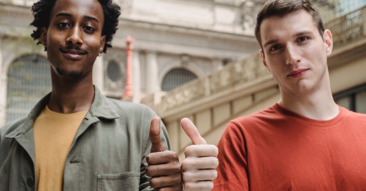 TV Programs like Good Eats - Positive young multiracial guys demonstrating thumbs up sign at camera