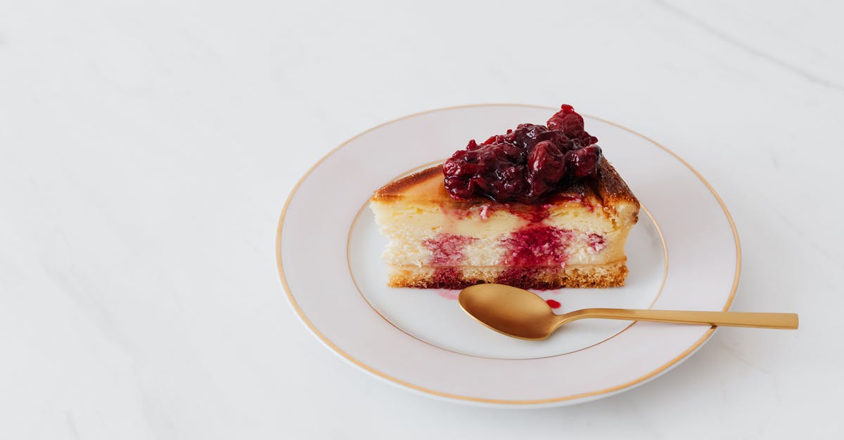 Undercooked center of a cheesecake baked at altitude - Piece of cheesecake on plate served with spoon