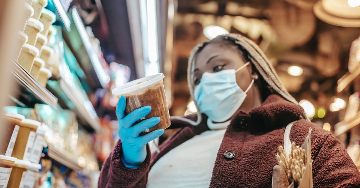 Unopened Canned Food in Spare Commercial Fridge - Safety & Storage for Prepping - Black woman in protective mask buying products Unopened Canned Food in Spare Commercial Fridge - Safety & Storage for Prepping - Black woman in protective mask buying products