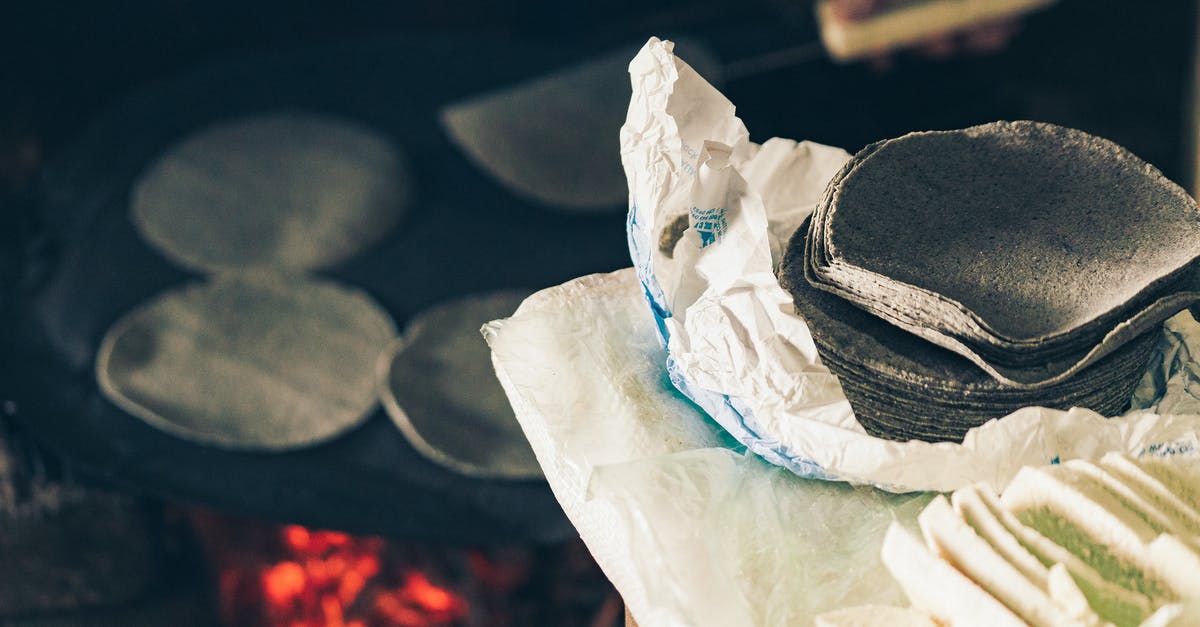 Unopened cheese shipped in heat - High angle of crop anonymous cook frying Mexican blue tortilla on fireplace near table with homemade cheese