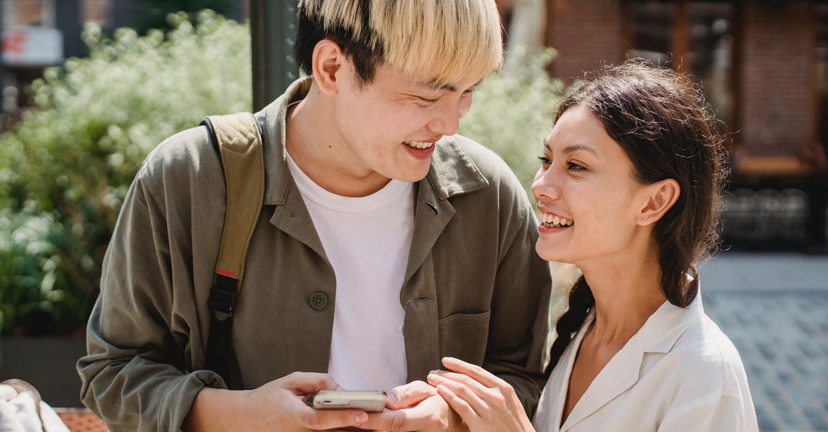 Use by date on cacao butter - Positive young multiethnic couple smiling and looking at each other on street