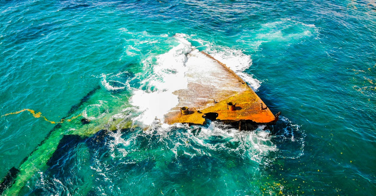 Used warm setting by accident [duplicate] - From above rusted grunge fragments of crashed boat lying in shallow sea and washed by clean green water