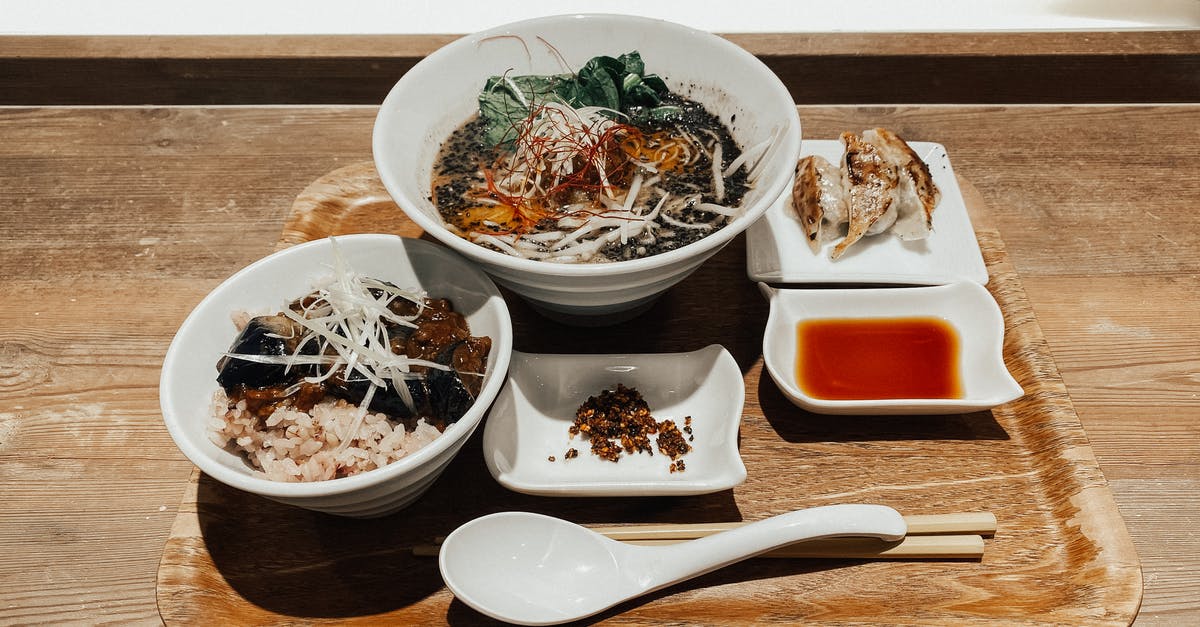 Using a wooden spoon to prevent pots from boiling over? - Delicious traditional Asian soup and rice with vegetables served on tray