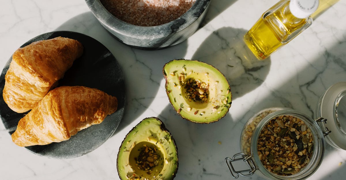 Using avocado oil as a substitute to olive oil - Fresh food and ingredients for healthy breakfast on marble desk