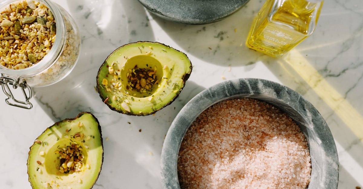 Using avocado oil as a substitute to olive oil - Fresh avocado halves with seed mix and other ingredients for healthy breakfast