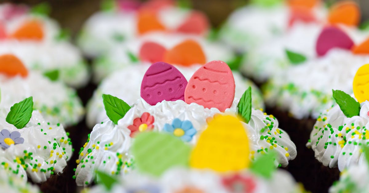 Using manual egg beater to cream eggs and sugar - Small tasty desserts with bright decorative eggs and leaves in whipped meringue cream during Easter holiday