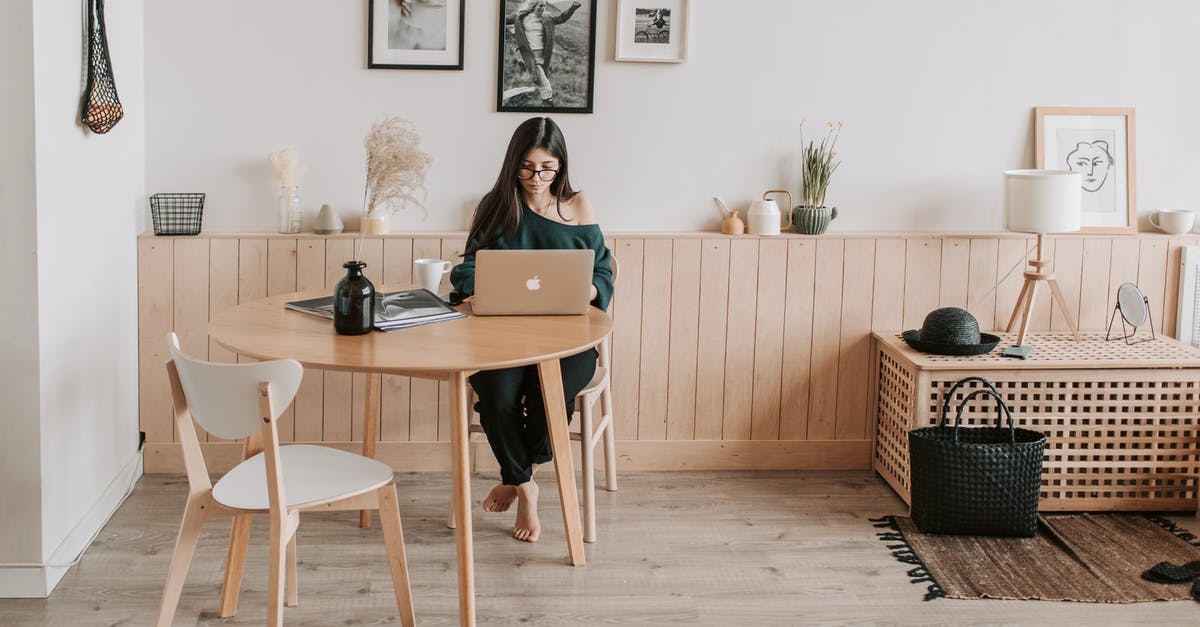 Using my own wood for smoking? - Full length of pensive brunette in eyeglasses sitting at table with legs crossed and working on laptop in cozy creative living room