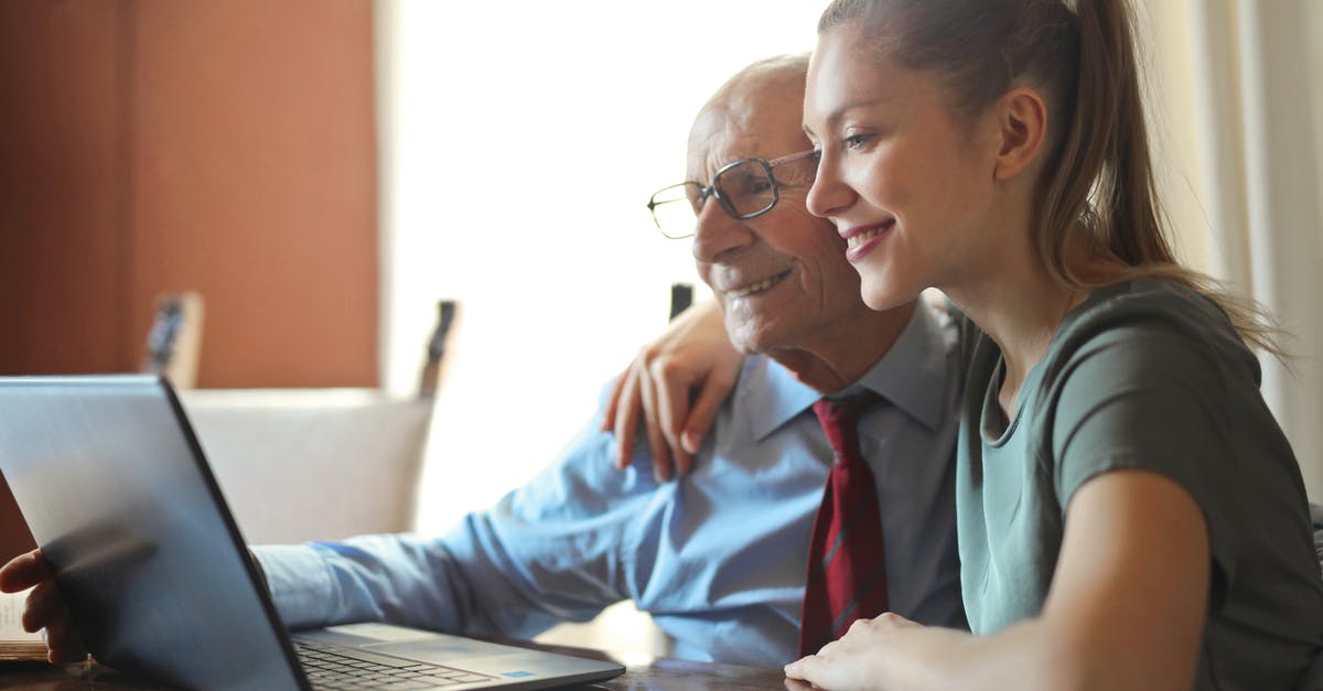 Using seltzer to help a marinade - Young positive woman helping senior man using laptop