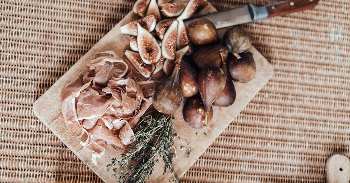 Using the bone from a spiral cut ham - Cut figs on wooden board with ham