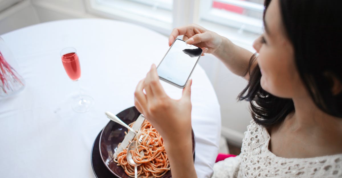 Using white wine in the cooking - Woman Taking A Photo Of Her Food