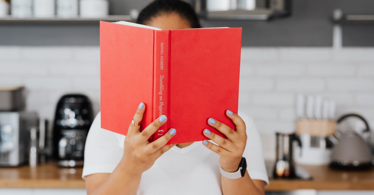 Using/selecting a centrifuge in the kitchen? - Man in White Shirt Holding Red Book