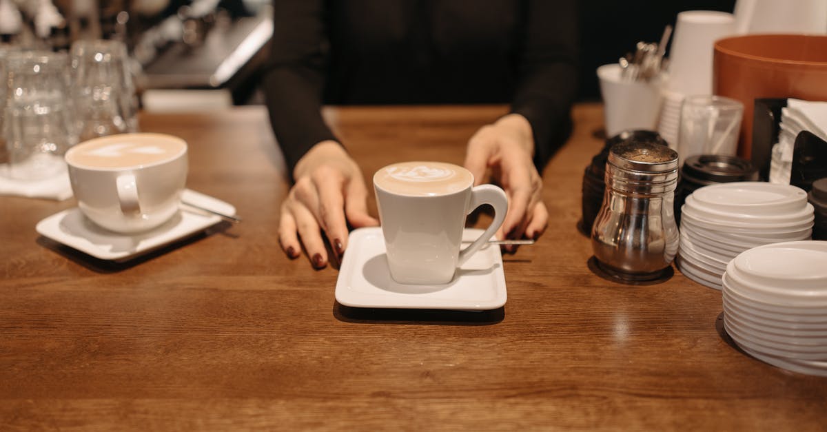 Vanilla extract cups vs spoon - Person Holding White Ceramic Mug on Brown Wooden Table