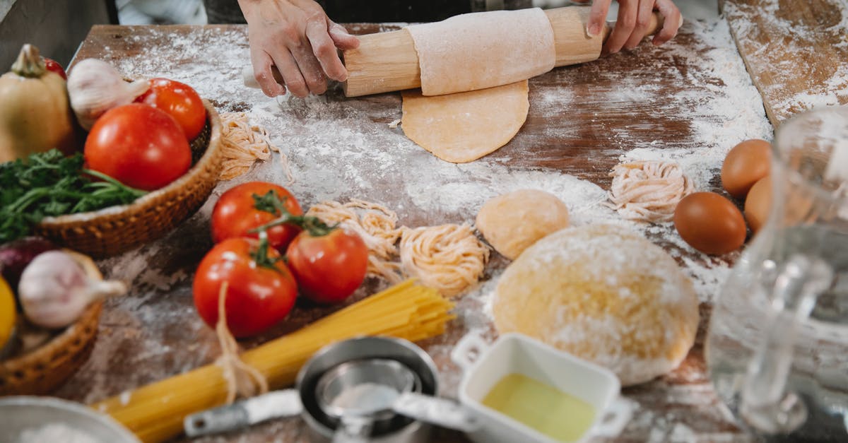 Vegan egg substitute in sweet roll dough - Woman rolling dough on table with tomatoes and eggs