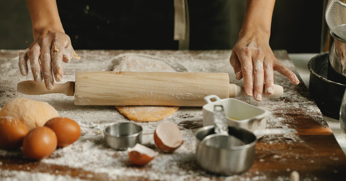 Vegan egg substitute in sweet roll dough - Chef rolling dough on table in kitchen