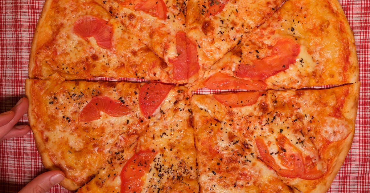 Vegan substitute for cheese [duplicate] - Top view of crop faceless person at table with pizza slices with tomatoes and cheese with seasoning